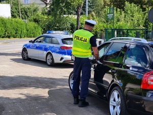 policjant przeprowadza kontrolę drogową