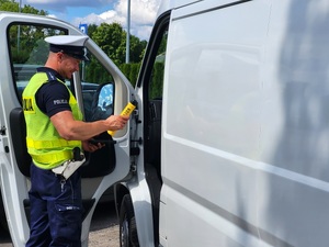 policjant przeprowadza kontrolę drogową