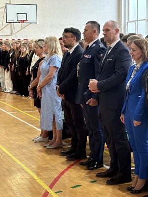 Na zdjęciu widać osoby wśród, których stoi policjant.